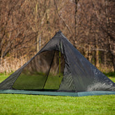DD Superlight XL Pyramid Mesh Tent set up in a grassy area, ideal for solo travelers seeking space without added weight.